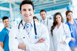 A group of medical professionals wearing lab coats and scrubs standing together for a photo