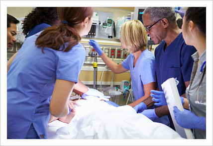 A group of doctors performing a medical procedure on a patient laying down